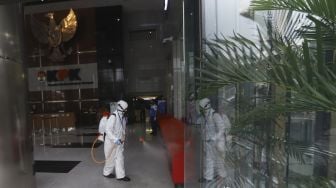 Petugas menyemprotkan cairan disinfektan pada bagian kursi di dalam gedung KPK, Jakarta, Rabu (18/3).[Suara.com/Angga Budhiyanto]