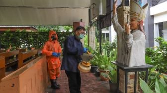 Petugas menyemprotkan disinfektan di bagian taman Gereja Katolik Santa Catharina di kawasan Taman Mini Indonesia Indah (TMII), Jakarta Timur, Rabu (18/3). [Suara.com/Alfian Winanto]
