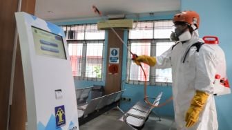 Petugas PMI menyemprotkan cairan disinfektan ke mesin layanan elektrik di Lapas kelas 1 Cipinang, Jakarta Timur, Jumat (20/3). [Suara.com/Alfian Winanto]