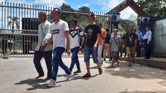 Sejumlah Pekerja Migran Indonesia (PMI) melintasi pintu pagar setibanya di Pos Lintas Batas Negara (PLBN) Entikong, Kabupaten Sanggau, Kalbar, Sabtu (21/3). [ANTARA FOTO/Agus Alfian]