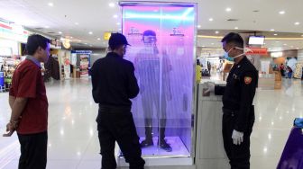 Penumpang diperiksa di ruang sterilisasi (Sterilization Chamber) yang terpasang di Terminal 2 Bandara Internasional Juanda di Sidoarjo, Jawa Timur, Minggu (22/3).  [ANTARA FOTO/Umarul Faruq]