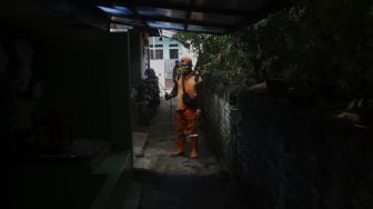 Petugas melakukan penyemprotan cairan disinfektan di Gang Haji Sairan, Kelurahan Jati Padang, Pasar Minggu, Jakarta Selatan, Kamis (26/3). [Suara.com/Angga Budhiyanto]