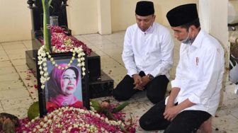 Presiden Joko Widodo memandang foto almarhumah ibundanya Sujiatmi Notomiharjo  di TPU Mundu, Kelurahan Selokaton, Kecamatan Gendangrejo, Kabupaten Karanganyar, Solo,  Kamis (26/3). [Foto/Agus suparto]