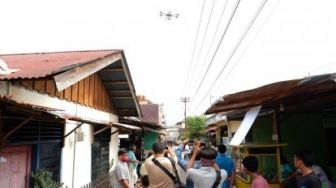 Polda Riau Semprot Disinfektan di Pemukiman Warga Menggunakan Drone
