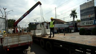 Pekerja melakukan proses penurunan beton movable concrete barrier (MBC) saat persiapan penutupan jalan di jalur Pantura Gajah Mada, Tegal, Jawa Tengah, Sabtu (28/3). [ANTARA FOTO/Oky Lukmansyah] 