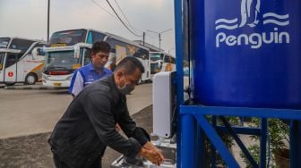 Warga mencuci tangan dengan Wastafel Portable di Terminal Depok, Jawa Barat, Sabtu (28/3). [Suara.com/Alfian Winanto]