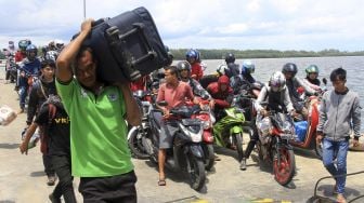 Sejumlah calon penumpang bersiap memasuki Kapal Motor Penyeberangan (KMP) Teluk Sinabang di Pelabuhan Penyeberangan Meulaboh-Sinabang Desa Gampong Teungoh, Samatiga, Aceh Barat, Aceh, Sabtu (28/3). [ANTARA FOTO/Syifa Yulinnas]