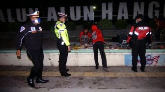 Petugas kepolisian membubarkan warga yang berkumpul di pinggir jalan di Slawi, Kabupaten Tegal, Jawa Tengah, Sabtu (28/3) malam. [ANTARA FOTO/Oky Lukmansyah]