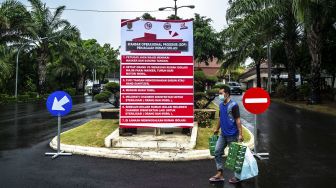 Petugas berjalan mengenakan masker di kawasan Rumah Isolasi Rumah Dinas Wali Kota Semarang, Jawa Tengah, Senin (30/3). [ANTARA FOTO/Aji Styawan]