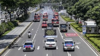 Petugas Gabungan menyemprotkan cairan disinfektan di sepanjang jalan Jenderal Sudirman-MH Thamrin, Jakarta, Selasa (31/3).  [ANTARA FOTO/Muhammad Adimaja]