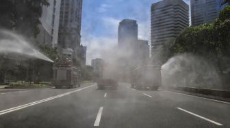 Penyemprotan cairan disinfektan di sepanjang jalan Jenderal Sudirman-MH Thamrin, Jakarta, Selasa (31/3).  [ANTARA FOTO/Muhammad Adimaja]