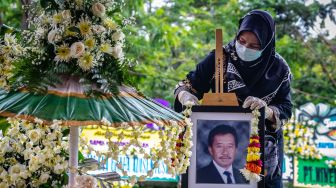 Kerabat mengalungkan bunga pada foto di pusara makam Mohamad Hasan Gatot Soebroto (Bob Hasan) saat prosesi pemakaman di Taman Makam Pahlawan Gatot Soebroto, Ungaran Timur, Kabupaten Semarang, Jawa Tengah, Rabu (1/4).  [ANTARA FOTO/Aji Styawan]