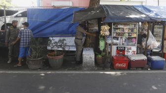 Petugas Menutup Warung Kelontong Untuk Cegah Corona