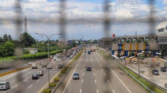 Kendaraan melintas di ruas jalan Tol Jorr, Jakarta, Kamis (2/4).   [Suara.com/Alfian Winanto]