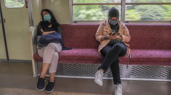 Penumpang Commuterline menerapkan Social Distancing dengan duduk berjauhan, Jakarta, Jumat (3/4). [Suara.com/Alfian Winanto]