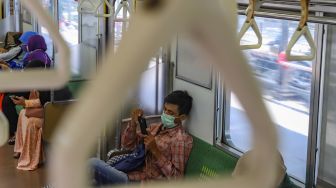 Aktivitas para penumpang didalam Commuterline, Jakarta, Jumat (3/4). [Suara.com/Alfian Winanto]

