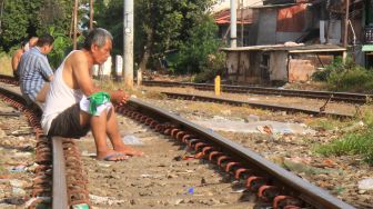 Tingkatkan Imun Tubuh,  Warga Menteng Berjemur di Rel Kereta Api