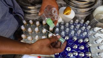 Pedagang menunjukkan botol yang digunakan untuk menampung handsinitizer di Pasar Tradisional Jatinegara, Jakarta Timur, Sabtu (4/4). [Suara.com/Alfian Winanto]
