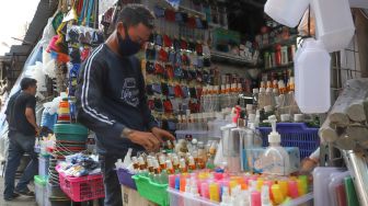 Pedagang merapikan  wadah  handsinitizer di Pasar Tradisional Jatinegara, Jakarta Timur, Sabtu (4/4). [Suara.com/Alfian Winanto]