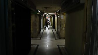 Pengunjung melintas di pertokoan tutup di Pasar Jatinegara, Jakarta Timur, Sabtu (4/4). [Suara.com/Alfian Winanto]