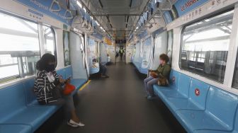 Penumpang menggunakan masker saat berada di dalam kereta Moda Raya Terpadu (MRT) di Stasiun MRT Lebak Bulus, Jakarta Selatan, Senin (6/4). [Suara.com/Angga Budhiyanto]