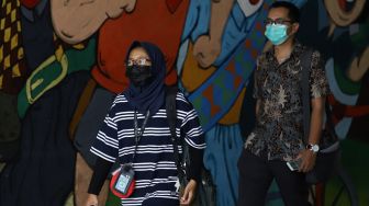 Sejumlah warga menggunakan masker melintas di lorong kawasan Stasiun Sudirman, Jakarta, Minggu (5/4). [Suara.com/Angga Budhiyanto]