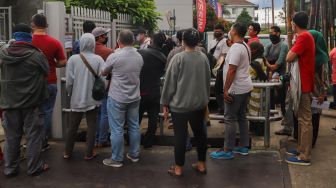 Antrean warga untuk membeli masker di sebuah pabrik di Jalan Raya Bogor, Depok, Jawa Barat, Selasa (7/4). [Suara.com/Alfian Winanto]
