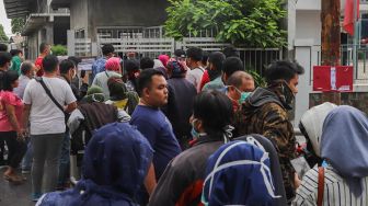 Sejumlah warga yang mengantre untuk membeli masker di sebuah pabrik di Jalan Raya Bogor, Depok, Jawa Barat, Selasa  (7/4).  [Suara.com/Alfian Winanto]
