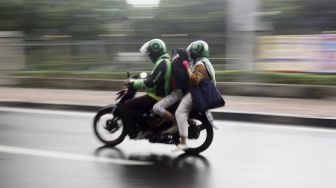 Driver ojek online membawa penumpang melintas di kawasan Palmerah, Jakarta, Selasa (7/4).  [Suara.com/Angga Budhiyanto]