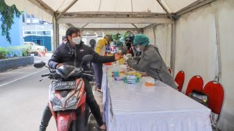 Petugas melakukan Rapid Test pada wartawan pengguna sepeda motor di area parkir Kementerian Komunikasi & Informatika, Jakarta Pusat, Rabu (8/4). [Suara.com/Alfian Winanto]