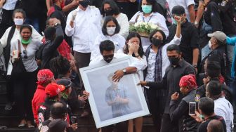 Istri dan kerabat saat mengantarkan jenazah Glenn Fredly dari rumah duka di GBIB Sumber Kasih, Lebak Bulus, Jakarta Selatan, Kamis (9/4). [Suara.com/Alfian Winanto]