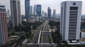 

Suasana jalan Jenderal Sudirman yang lengang di Jakarta Pusat, Jumat (10/4). [ANTARA FOTO/Sigid Kurniawan]