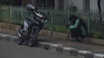 Pengendara ojek online menunggu pesanan di kawasan Kemang, Jakarta, Jumat (10/4). [Suara.com/Angga Budhiyanto] 