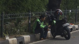 Pengendara ojek online menunggu pesanan di kawasan Senayan, Jakarta, Jumat (10/4). [Suara.com/Angga Budhiyanto] 