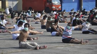 Sejumlah Tenaga Kerja Indonesia (TKI) asal Malaysia mengikuti senam dan berjemur di bawah sinar matahari saat menjalani karantina di Pangkalan Udara Militer (Lanud) Soewondo Medan, Sumatera Utara, Sabtu (11/4). [ANTARA FOTO/Septianda Perdana]