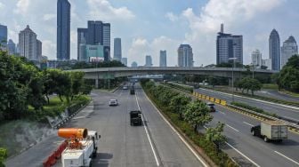 Petugas gabungan  melakukan penyemprotan cairan disinfektan dengan menggunakan mobil gunners spraying dikawasan Gatot Soebroto, Jakarta, Minggu (12/4).  [ANTARA FOTO/Nova Wahyudi]
