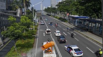 Penyemprotan cairan disinfektan dengan menggunakan mobil gunners spraying dikawasan Gatot Soebroto, Jakarta, Minggu (12/4).  [ANTARA FOTO/Nova Wahyudi]
