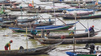 Nelayan Kampung Bulak Cumpat beraktivitas di atas perahu yang ditambatkan di Pantai Kenjeran, Surabaya, Jawa Timur, Minggu (12/4). [ANTARA FOTO/Moch Asim]