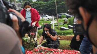 Mutia Ayu saat berdoa di makam musisi Glenn Fredly  di TPU Tanah Kusir, Jakarta Selatan, Minggu (12/4). [Suara.com/Alfian Winanto]