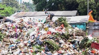 Petugas memilah sampah di TPS Kalibata, Jakarta Selatan, Senin (13/4). [Suara.com/Alfian Winanto]