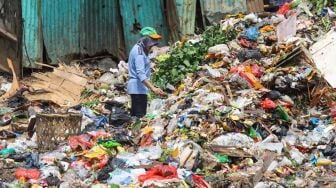 Pemulung memilah sampah di TPS Kalibata, Jakarta Selatan, Senin (13/4).  [Suara.com/Alfian Winanto]