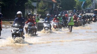 Kendaraan bermotor menerobos banjir yang menggenangi kawasan Jalan Raya Pantura Kraton, Pasuruan, Jawa Timur, Selasa (14/4).  [ANTARA FOTO/Umarul Faruq]