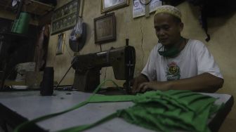 Pekerja menyelesaikan pembuatan alat pelindung diri (APD) tenaga medis dan non medis di sebuah industri rumahan, di Kawasan Manggarai, Jakarta, Rabu (15/4). [Suara.com/Angga Budhiyanto]