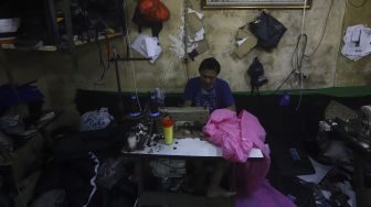 Pekerja menyelesaikan pembuatan alat pelindung diri (APD) tenaga medis dan non medis di sebuah industri rumahan, di Kawasan Manggarai, Jakarta, Rabu (15/4). [Suara.com/Angga Budhiyanto]