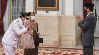 Presiden Joko Widodo memakai masker (kanan) mengucapkan selamat kepada Wakil Gubernur DKI Jakarta Ahmad Riza Patria (kiri) seusai dilantik di Istana Negara, Jakarta, Rabu (15/4).  [ANTARA FOTO/Hafidz Mubarak]