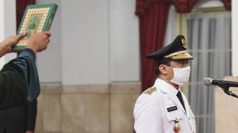 Wakil Gubernur DKI Jakarta Ahmad Riza Patria memakai masker saat  membaca sumpah saat dilantik di Istana Negara, Jakarta, Rabu (15/4). [ANTARA FOTO/Hafidz Mubarak]
