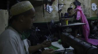 Pekerja menyelesaikan pembuatan alat pelindung diri (APD) tenaga medis dan non medis di sebuah industri rumahan, di Kawasan Manggarai, Jakarta, Rabu (15/4). [Suara.com/Angga Budhiyanto]