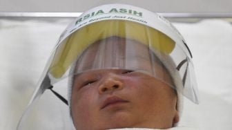 Bayi mengenakan pelindung muka atau face shield di RS Ibu dan Anak Asih, Jakarta, Jumat (17/4).  [ ANTARA FOTO/Puspa Perwitasari]

