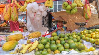 Pedagang buah istirahat makan siang di Pasar Minggu, Jakarta Selatan, Jumat (17/4). [Suara.com/Alfian Winanto]
