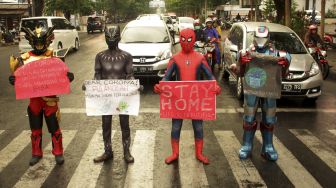 Sejumlah relawan menggunakan kostum "Super Hero" saat melakukan kampanye melawan COVID-19 di Makassar, Sulawesi Selatan, Jumat (17/4). [ANTARA FOTO/Arnas Padda]